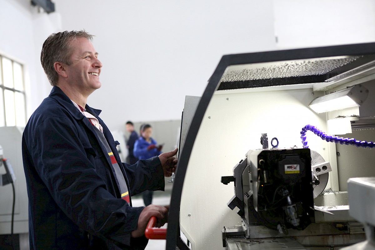 lachender Mann an Maschine